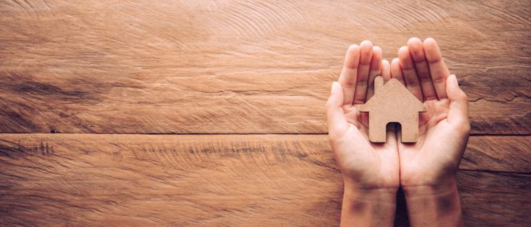 hands holding wooden house licensee accountability