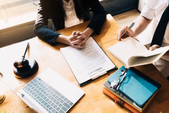 Papers on a desk with people sitting around in discussion